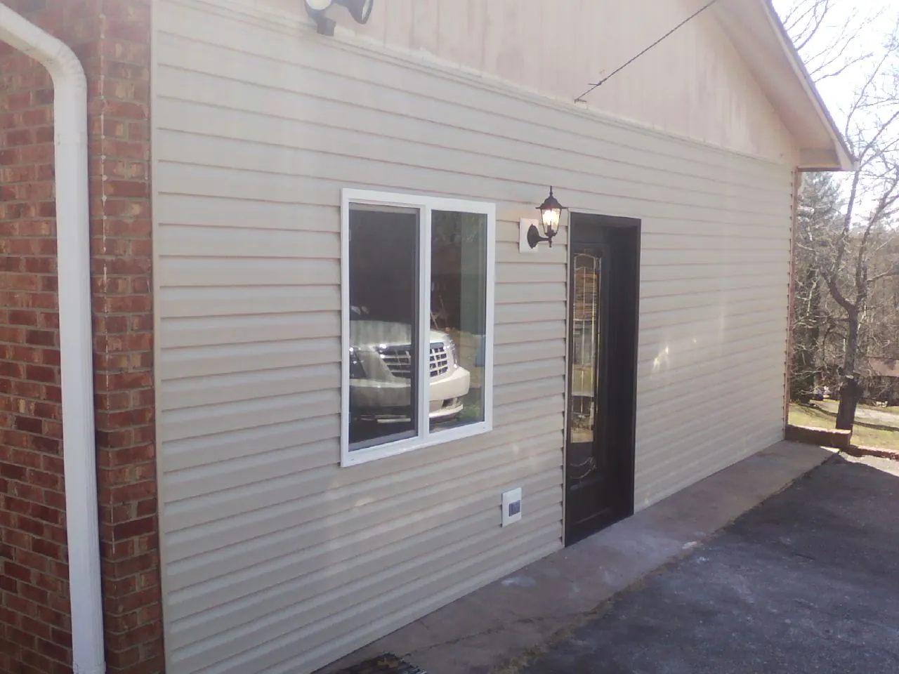 New vinyl siding and entry door on a room addition in Etna