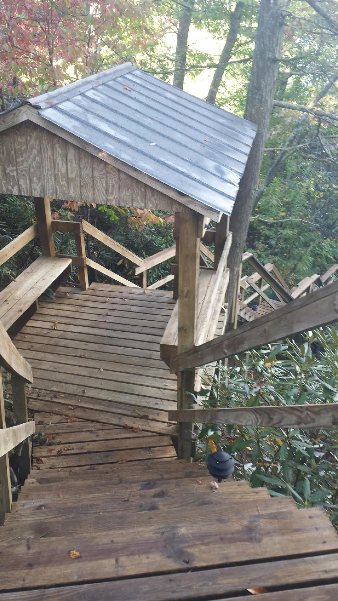 Metal roofed shelter over wooden steps on a wooded walkway — Skylight Repair & Installation work by our crew in Etna