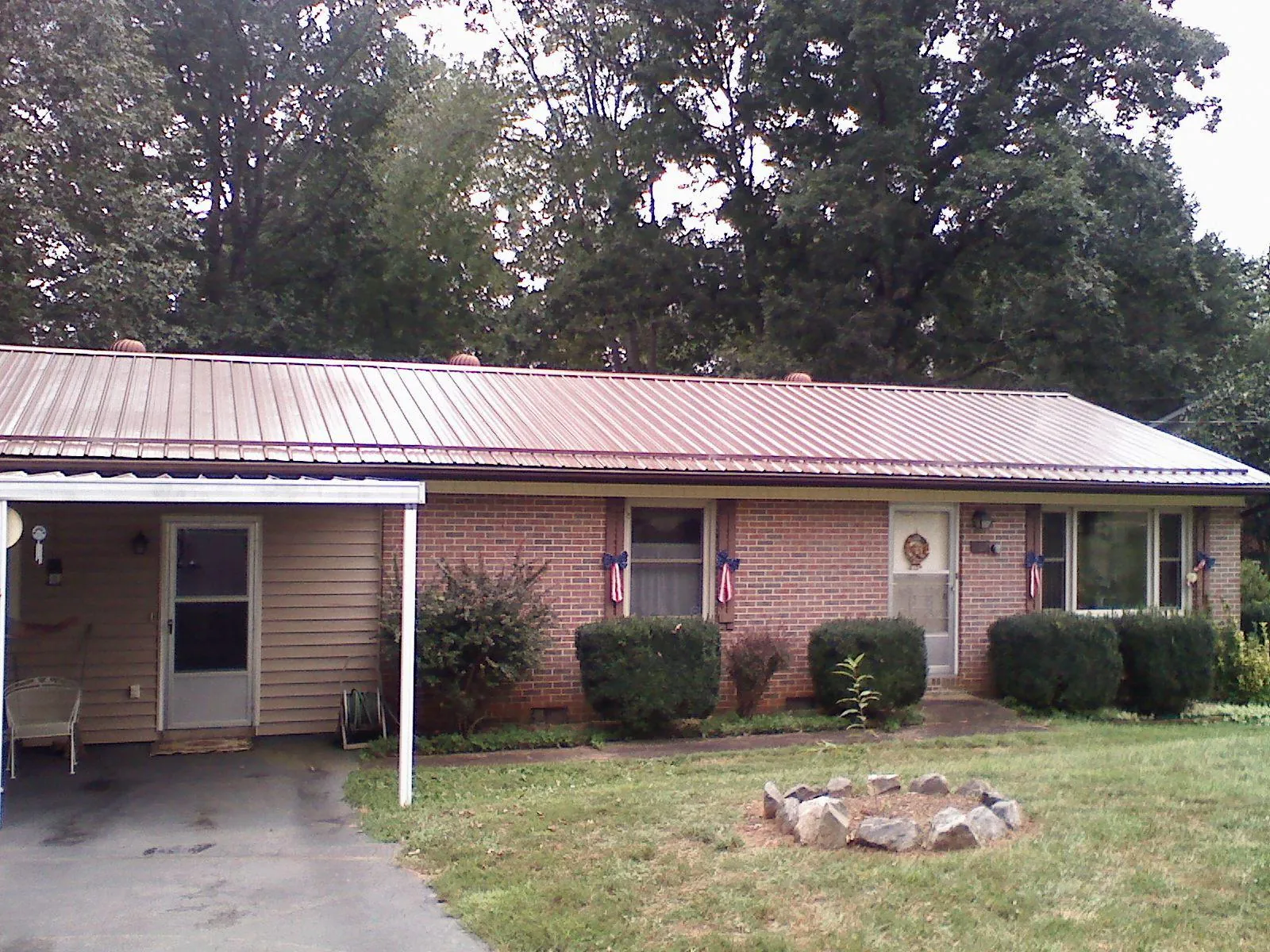 Bronze metal roof and carport on a brick ranch home — Roof Repair work by our crew in Etna
